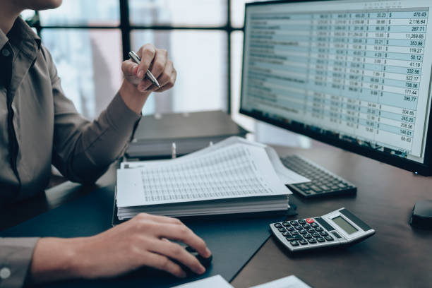 c7 Investors working on desk office and check data cost, balance, profit and currency on monitor screen. Accounting and Financial concept.